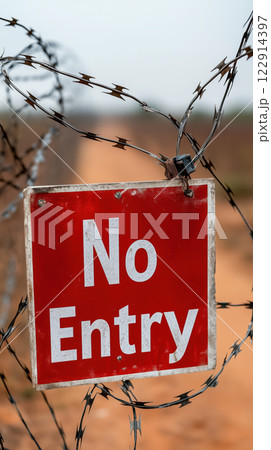 No entry sign on barbed wire fence, indicating restricted access 122914397