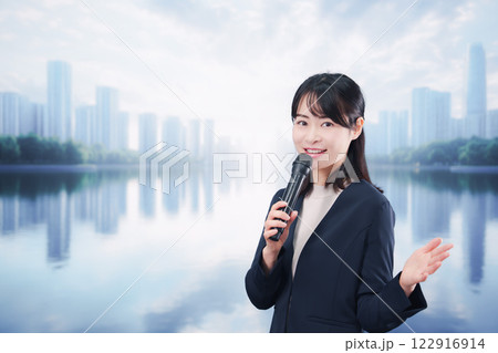 街角でマイクを使って演説をする若い女性 122916914