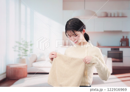 家で洗濯物をたたむ若い女性 家で洗濯物をたたむ若い女性 122916969