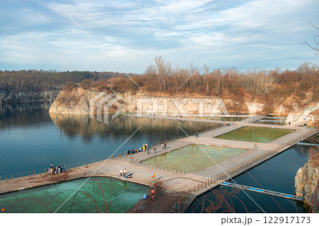 Swimming, paddling pools, sunbathing platforms on Zakrzowek lake with steep cliffs in place of former flooded limestone quarry. New public recreational place. Aerial view Swimming, paddling pools, sunbathing platforms on Zakrzowek lake with steep cliffs in place of former flooded limestone quarry. New public recreational place. Aerial view 122917173