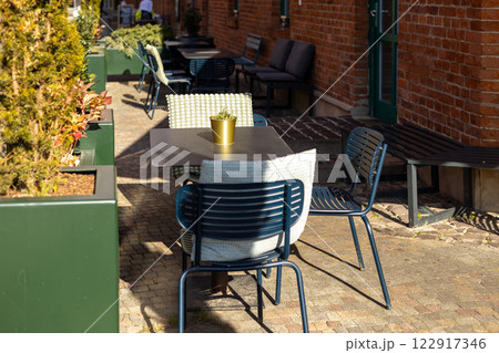 Outdoor street cafe tables ready for service. Empty cafe terrace with table and plastic chair, morning time. Food concept 122917346