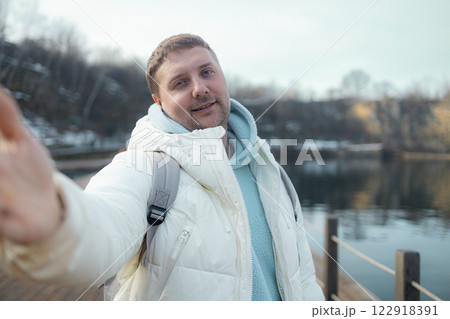 Young happy man takes selfie photo during his awesome hiking trek somewhere in forest, walking by the lake 122918391