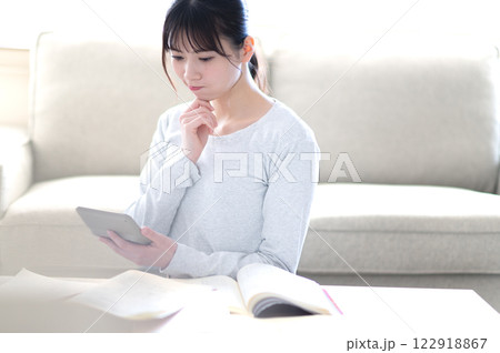 リビングで一人で勉強する若い女性 122918867