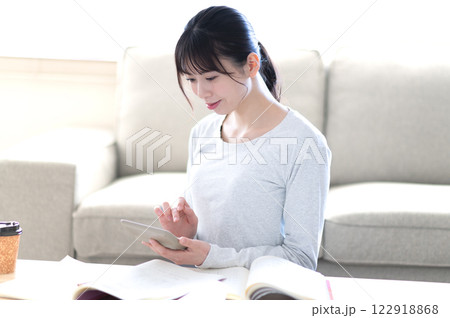 リビングで一人で勉強する若い女性 122918868
