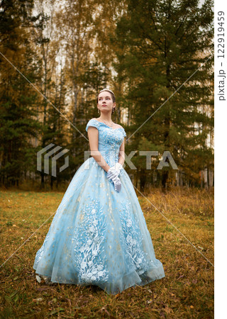 Beautiful brunette girl in a blue ball gown in a colorful forest 122919459