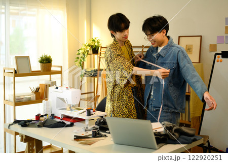 Two young designers brainstorming ideas while working on denim collection 122920251