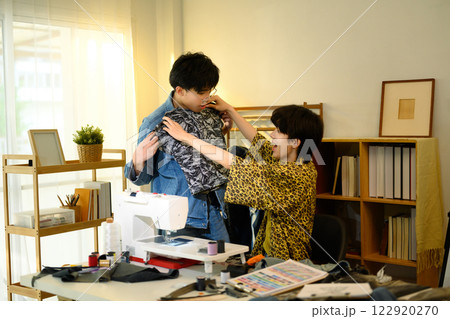 Creative fashion designers collaborating in a stylish workspace 122920270