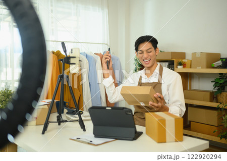 Cheerful young entrepreneur in an apron celebrating sales growth at workplace 122920294