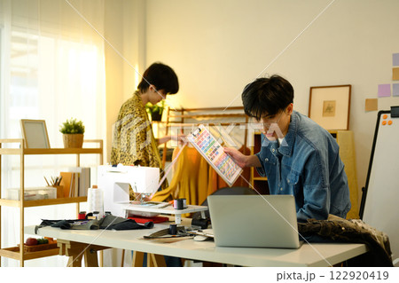 Fashion designers working on a creative project in stylish workspace Fashion designers working on a creative project in stylish workspace 122920419