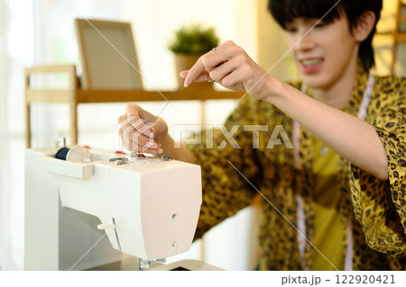 Cropped shot of young fashion designer threading a sewing machine 122920421