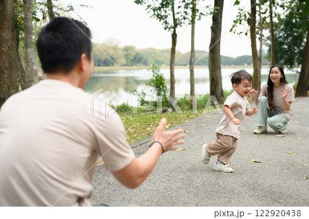Adorable happy little boy running towards father with joyful expressions Adorable happy little boy running towards father with joyful expressions 122920438