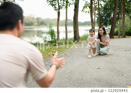 Excited little child running to father with open arms in the park Excited little child running to father with open arms in the park 122920443