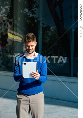 Smiling young entrepreneur using digital tablet in the city 122920557