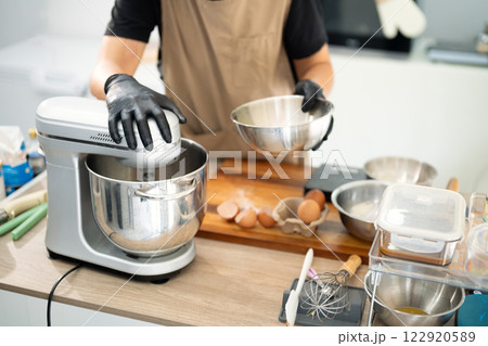Male baker using a stand mixer to make cookie dough Male baker using a stand mixer to make cookie dough 122920589