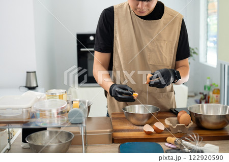 Baker separating eggs preparing for a delicious batch of homemade cookies 122920590