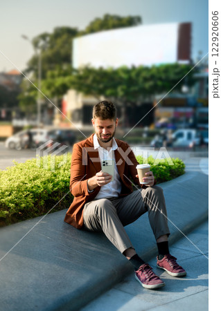 Young businessman using a smartphone outdoors in a modern urban 122920606