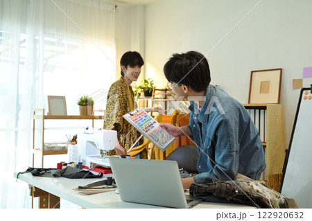 Fashion designers collaborating on a new clothing collection in a creative studio 122920632