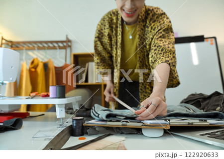 Stylish tailor working on a new garment design in a fashion studio Stylish tailor working on a new garment design in a fashion studio 122920633
