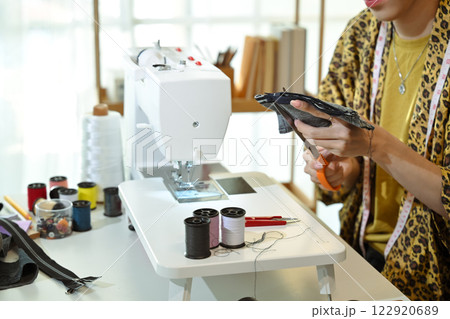 Tailor or seamstress cutting fabric with precision preparing material for sewing 122920689