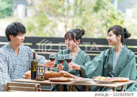 浴衣姿でバルコニー・ウッドデッキで乾杯する男女・同僚・仲間 122920929