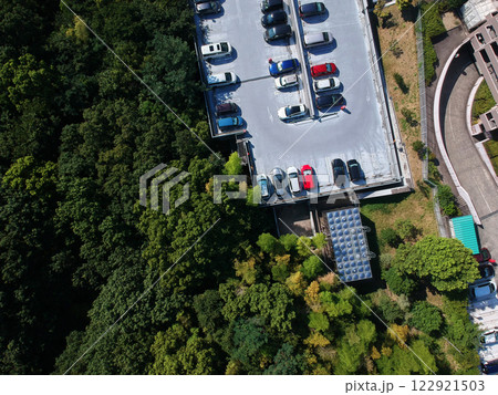 空撮した公園の森と住宅街のマンションの駐車場の風景 122921503