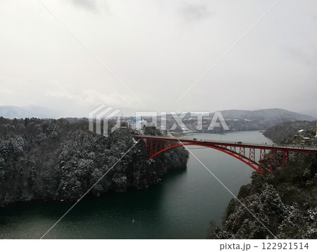 ドローンで空撮した冬の観光名所恵那峡大橋の雪景色 122921514