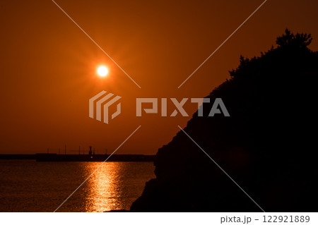 島根県の出雲市にある稲佐の浜の弁天島に沈む夕日の風景 島根県の出雲市にある稲佐の浜の弁天島に沈む夕日の風景 122921889