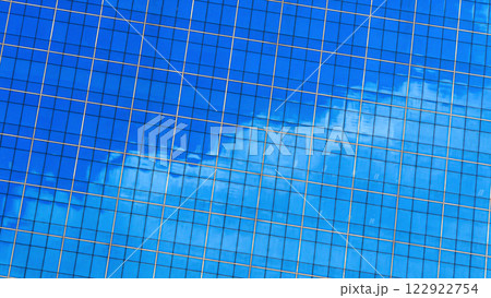 a vibrant blue glass facade with golden gridlines, reflecting the sky and creating a striking, modern architectural design. 122922754