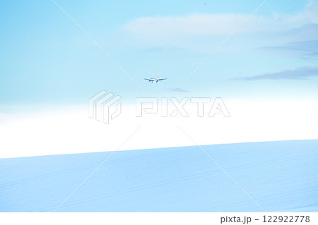 雪原の向こうに着陸する飛行機が見える風景 122922778