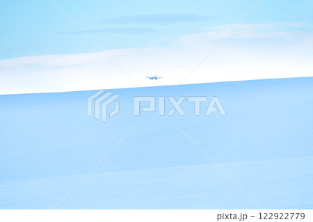 雪原の向こうに着陸する飛行機が見える風景 122922779