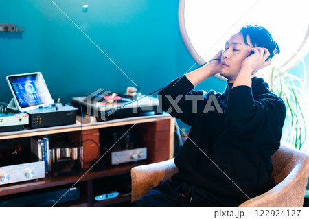 音楽を温泉ヘッドフォンで聞くミドルの男性 122924127