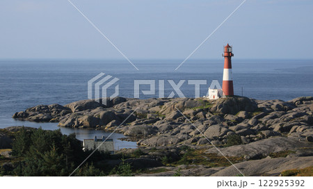 Eigeroy lighthouse, rock formations and sea, Norway. 122925392