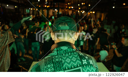 DJ Plays to Energetic Crowd at Outdoor Music Festival Under Bokeh Lights DJ Plays to Energetic Crowd at Outdoor Music Festival Under Bokeh Lights 122926047