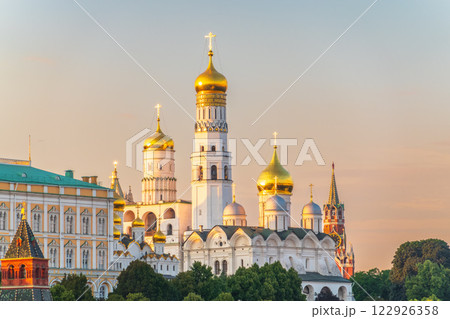 Ivan the Great Bell Tower, with Assumption Belfry on the right in Moscow Kremlin. Blue sky background with sunbeams Ivan the Great Bell Tower, with Assumption Belfry on the right in Moscow Kremlin. Blue sky background with sunbeams 122926358
