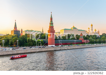 View of Kremlin with Vodovzvodnaya tower, Grand Kremlin Palace from repaired Bolshoy Kamenny Bridge in Moscow city on sunny summer day. Cruise ship sails on the Moscow river 122926362