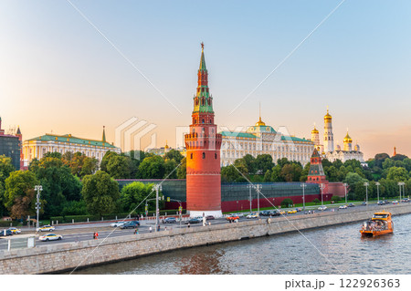 View of Kremlin with Vodovzvodnaya tower, Grand Kremlin Palace from repaired Bolshoy Kamenny Bridge in Moscow city on sunny summer day. Cruise ship sails on the Moscow river 122926363