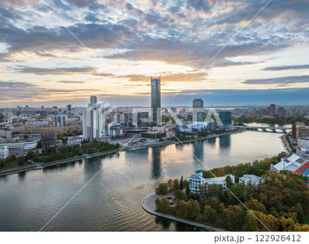 Yekaterinburg city and pond aerial panoramic view at summer or early autumn sunset. Night city in the early autumn or summer. Yekaterinburg city and pond aerial panoramic view at summer or early autumn sunset. Night city in the early autumn or summer. 122926412