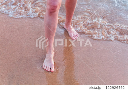 Beach - women's foot and the grains of sand. Beach - women's foot and the grains of sand. 122926562