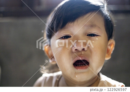 Tears flow from the eyes of boy. Dramatic portrait of a crying boy. The upset child. 122926597