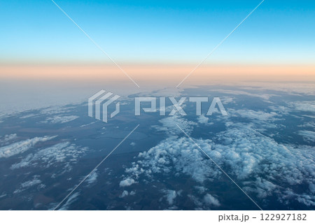 View of the earth and clouds from an airplane against the backdrop of the evening belt of Venus View of the earth and clouds from an airplane against the backdrop of the evening belt of Venus 122927182