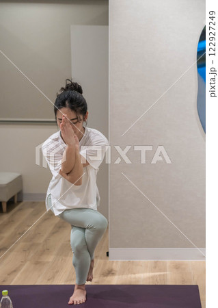 室内でヨガをしている若い女性 122927249