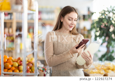 Woman scanning QR code or barcode bottle of water in supermarket Woman scanning QR code or barcode bottle of water in supermarket 122927274