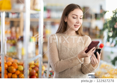 Young woman scanning qr code of soy sauce Young woman scanning qr code of soy sauce 122927278