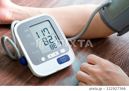 Man check blood pressure monitor and heart rate monitor with digital pressure gauge. Health care and Medical concept Man check blood pressure monitor and heart rate monitor with digital pressure gauge. Health care and Medical concept 122927366