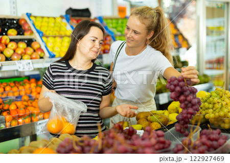 Teenage girl and her mother buying grape at grocery Teenage girl and her mother buying grape at grocery 122927469