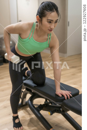 室内のジムで筋トレをする若い女性 122927608