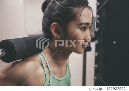 室内のジムで筋トレをする若い女性 122927622