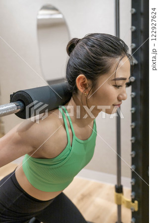 室内のジムで筋トレをする若い女性 室内のジムで筋トレをする若い女性 122927624