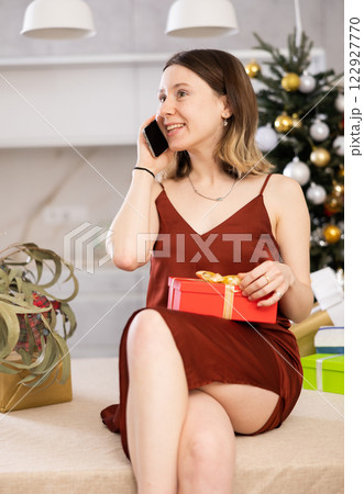 Cheerful woman is discussing something with someone on mobile Cheerful woman is discussing something with someone on mobile 122927770