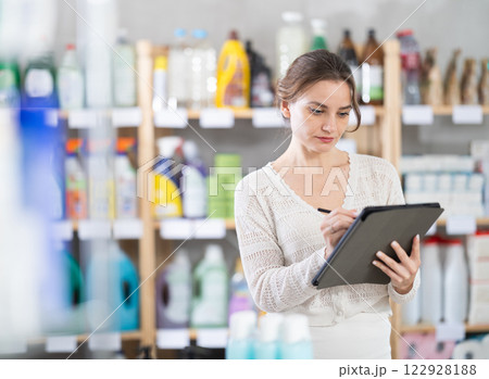 Young woman seller conducting inventory with tablet 122928188